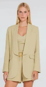 Blazer de sastreria color rosado viejo, de diseño estructurado con solapas tipo chal y bolsillos con solapa en el frente.