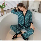Conjunto de pijama de dos piezas compuesto por una camisa de manga larga con cuello mao y cierre frontal de botones, y un pantalón largo. Presenta un diseño estampado de corazones sobre fondo negro con detalles en color blanco.