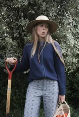 Campera tejida de punto con textura de rayas verticales, cierre frontal completo y cuello alto. Diseño de manga larga con hombros caídos.