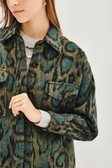 Tapado tipo sobrecamisa con estampado animal print, de corte recto y largo a la cadera. Presenta cuello camisero, cierre frontal con botones y dos bolsillos frontales con solapa.