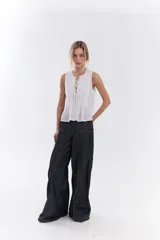 Blusa blanca sin mangas de algodón, con diseño de tablas frontales y escote con lazos para atar.