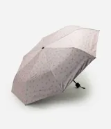 Sombrilla plegable color rosado con estampado de corazones, estructura de hierro y poliéster, mango reforzado con correa de muñeca y apertura manual.
