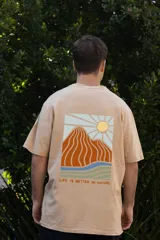 Remera color beige de manga corta con estampado de un sol en el pecho. Corte clásico y cuello redondo.