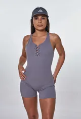 Catsuit deportivo gris con escote halter y cordones ajustables en el pecho.