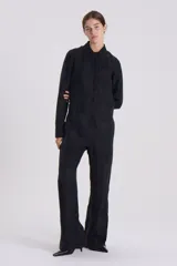 Mono largo negro de corte holgado, con cuello camisero, cierre frontal con cremallera y mangas largas.