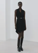 Vestido corto negro sin mangas, con cuello en V, diseño recto, bajo asimétrico y un fino cinturón incluido.