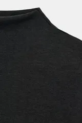 Camiseta de corte slim fit, color negro, con cuello subido y manga corta.