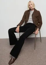 Jeans de terciopelo color negro, tiro alto y estilo flare, con diseño de cinco bolsillos y trabillas para cinturón.