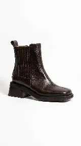 Bota tipo chelsea de cuero color suela, con paneles elásticos laterales, puntera cuadrada y suela de goma con taco de madera de diseño geométrico.