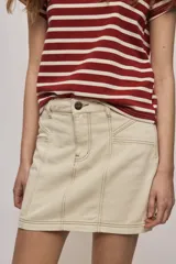 Falda de denim blanca de corte recto con bolsillos delanteros aplicados, costuras pespunteadas a contratono y cierre frontal con botón y cremallera.