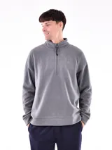 Buzo de polar gris, con cuello alto y cierre parcial frontal. Presenta un pequeño logo bordado en el pecho.