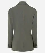Blazer de sastrería color verde oliva, con corte oversized, solapas clásicas, cierre frontal de un botón y bolsillos con tapa. Cuenta con forro interno y textura sutil.