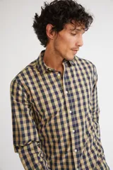 Camisa de manga larga con cuello clásico y cierre frontal abotonado. Presenta un estampado de cuadros en tonos azul marino y rojo. Confeccionada en algodón, cuenta con un corte slim fit y logo bordado en el pecho.