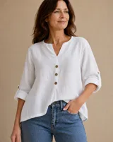 Blusa blanca de lino, con escote en V y cuello mao. Cuenta con mangas tres cuartos con presilla para arremangar y tres botones frontales.