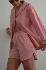 Camisa a rayas rojas y blancas de manga larga, con cuello clásico y corte holgado.