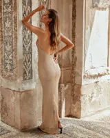 Vestido largo de tejido dorado con breteles finos y escote drapeado.