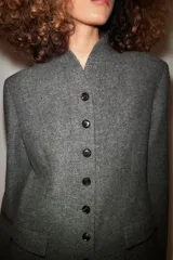 Abrigo largo gris melange de lana de la colección ZW de Zara, con cuello subido, cierre frontal abotonado y bolsillos con solapa en el delantero.