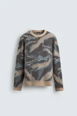 Jersey de punto cepillado con ajuste relajado, cuello redondo y manga larga. Presenta un diseño jacquard con patrón abstracto en tonos tierra, gris y azul, con terminaciones en rib en cuello, puños y ruedo.