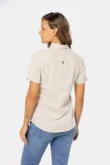Camisa de lino de manga corta con cuello camisero, cierre frontal de medio botón con botones metálicos personalizados y dos bolsillos en el pecho.