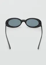 Gafas de sol con diseño ovalado y montura de pasta color negro, con cristales oscuros.