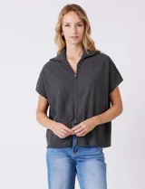 Cardigan gris jaspeado de punto de galga media, con cierre frontal metálico completo y cuello con solapa. Presenta mangas cortas de sisa caída y un corte recto y holgado que llega a la altura de la cadera.