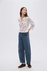 Pantalón jean de tiro medio, con diseño barrel (silueta curva) en tono azul clásico.