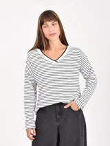 Remera de manga larga con estampado de rayas horizontales blancas y negras, cuello en V con ribete negro.