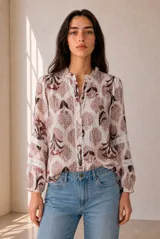 Camisa de manga larga color blanco con estampado floral en tonos marrones y rosados, cuello mao con volado y detalles de encaje en la botonera y las mangas.