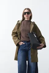 Polera de punto color marrón, con cuello alto y diseño de trenzas verticales en el frente y tejido acanalado en las mangas. Presenta mangas raglán y terminaciones acanaladas en puños y ruedo.