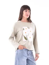 Remera de manga larga color verde claro, con cuello redondo y un estampado frontal de flores blancas sobre un fondo rosado.