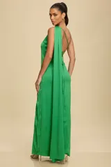 Vestido largo de un solo hombro confeccionado en crepe satinado, con caída fluida, tajo lateral profundo y detalle de capa larga que cae desde el hombro.