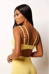 Conjunto deportivo de top y short seamless color amarillo, confeccionado con textura canelada y tecnología sin costuras. El top presenta diseño minimalista y el short incluye cintura alta y efecto push up.