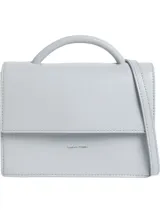 Cartera de mano Calvin Klein estructurada, color celeste pálido, con asa superior tubular y correa ajustable para cruzar. Presenta cierre desplegable con pulsador y logo metálico grabado en el frente.