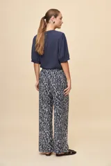 Pantalón gris de corte amplio y silueta fluida, con cintura elástica y cordón ajustable.