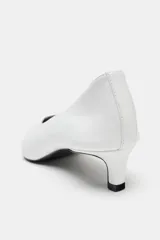 Zapato de tacón tipo kitten, confeccionado en piel soft color blanco, con diseño de escote en pico, acabado en punta y tacón fino.