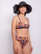 Conjunto de bikini con corpiño triangular con breteles finos y bombacha de tiro alto. Estampado multicolor con motivos florales y geométricos.