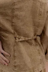Chaqueta de jean azul, de corte entallado, con cuello camisero, cierre frontal con botones y bolsillos delanteros con solapa.