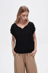 Blusa de viscosa color marrón, de manga corta, cuello en V y textura arrugada.