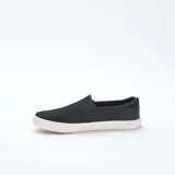 Zapatillas bajas slip-on negras de malla con suela blanca.