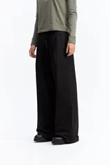 Pantalón de vestir negro de corte wide leg, con cintura elástica ajustable mediante cordón, pliegues frontales y diseño holgado.