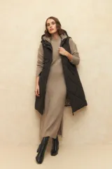 Chaleco largo marrón capitoneado con capucha, cierre frontal y bolsillos laterales. Forro interno de satén con estampado animal print.