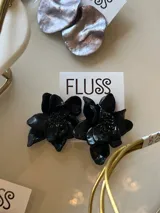 Par de aros colgantes con forma de flor grande, color negro.