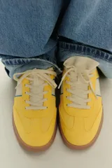 Zapatillas deportivas amarillas con detalles en azul y blanco.