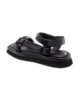 Sandalia plana color crema con plataforma baja y tiras acolchadas. Se ajusta con velcro en el tobillo.