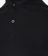 Chomba celeste de corte slim, confeccionada en tejido piquet texturizado de algodón, con cuello mao y cierre frontal parcial con botones.