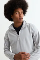 Buzo de polar gris con cuello alto y cierre frontal parcial, de manga larga y ajuste cómodo.