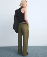 Jeans de corte recto y tiro medio color verde militar, confeccionados en 100% algodón, con diseño clásico de cinco bolsillos y cierre frontal con botón y cremallera.