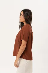 Blusa marrón de mangas cortas con cuello redondo y corte holgado.