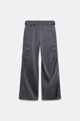 Pantalón cargo de tiro medio confeccionado en tejido satinado. Presenta bolsillos laterales con solapa, corte recto y holgado, y un cinturón integrado del mismo tejido con hebilla metálica.