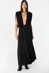 Vestido largo de color negro con escote profundo en V, diseño sin mangas con hombreras y detalle de fruncido lateral en la cintura que crea un efecto drapeado en la falda.